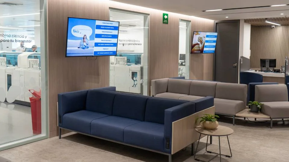 Salle d'attente moderne et confortable équipée d'écrans informatifs pour le suivi du flux des clients